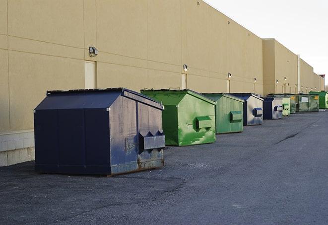 construction workers toss wood scraps into a dumpster in Billerica